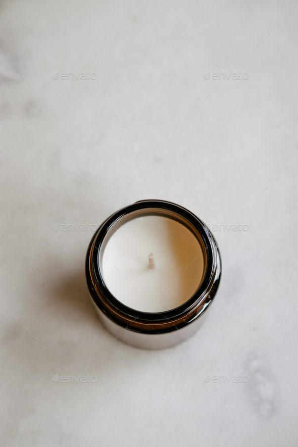 Candle in brown glass on white minimalist product photo Stock Photo by